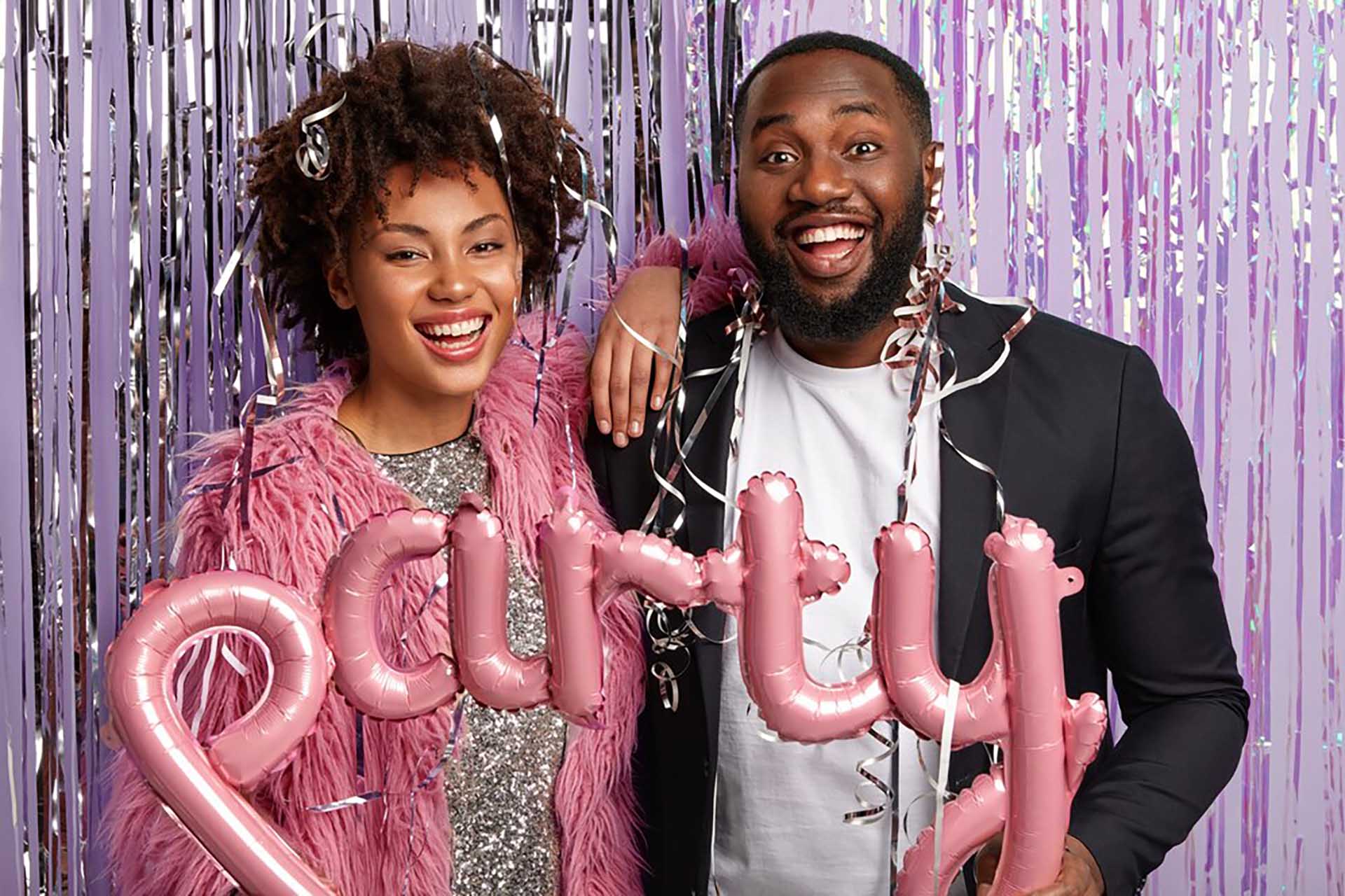 horizontal-shot-optimistic-couple-pose-together-with-tinsel-balloons_273609-27083